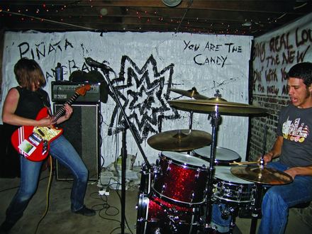 A band playing in front of the piñata wall
